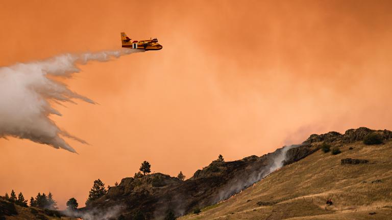 An aircraft dumps water on the edge of the Elmo Fire burning on the western shore of Flathead Lake on August 1, 2022.