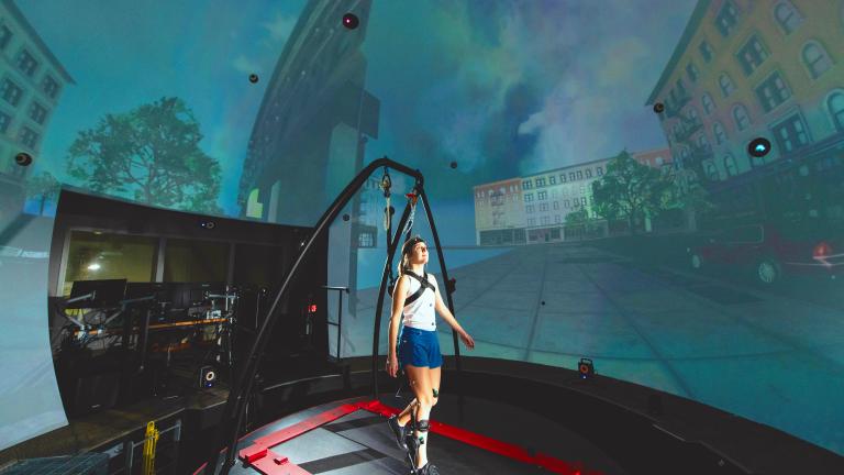 In the STRIVE Center, an immersive virtual reality facility overseen by the Biotechnology and Human Systems Division at Lincoln Laboratory, researchers collect data as a user tests a prototype ankle exoskeleton.