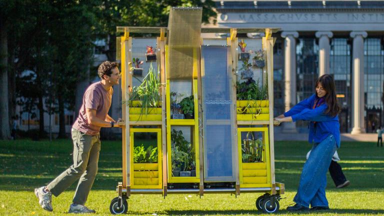 Zachary Rapaport (left) and Aleks Banaś move their farm cart across the MIT campus. The two graduate architecture students co-designed and built the cart.