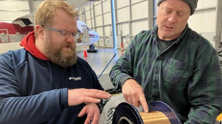 Lincoln Laboratory’s Ben Evans (left) and Dave Whelihan deployed this spool — featuring 230 feet of polymer fiber with embedded temperature and depth sensors — in the Arctic. 