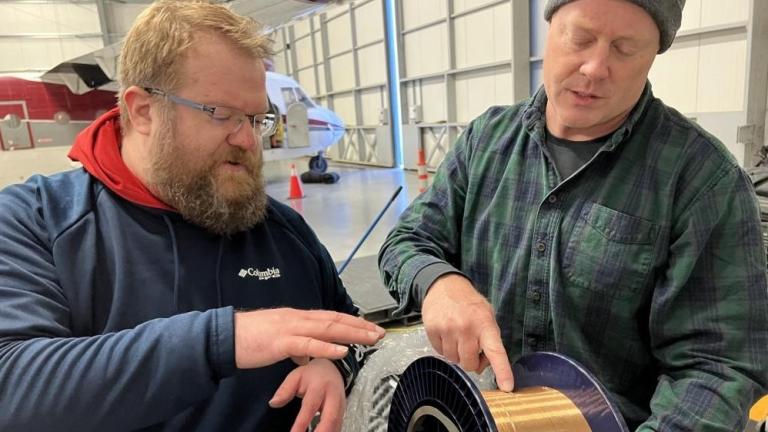 Lincoln Laboratory’s Ben Evans (left) and Dave Whelihan deployed this spool — featuring 230 feet of polymer fiber with embedded temperature and depth sensors — in the Arctic.