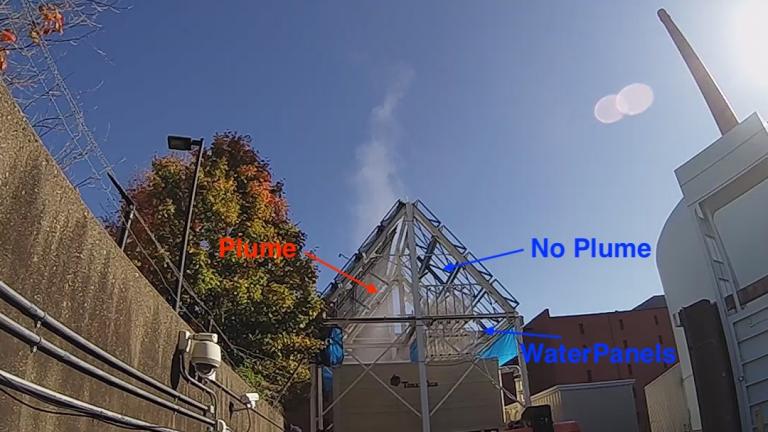 The cooling tower of MIT’s nuclear plant has demonstrated the effectiveness of the new water recovery system. The right side of the tower has the new system installed, eliminating its plume of vapor, while the untreated left side continues to produce a steady vapor stream.