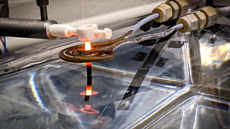 A thin rod of 3D-printed superalloy is drawn out of a water bath, and through an induction coil, where it is heated to temperatures that transform its microstructure, making the material more resilient. The new MIT heat treatment could be used to reinforce 3D-printed gas turbine blades.