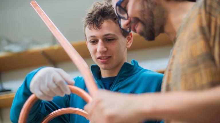 Rising MIT sophomore Sam Packman (left) and his advisor Nicolo Riva, a postdoc at the MIT Plasma Science and Fusion Center, examine a VIPER cable, a special type of high-temperature superconducting cable that holds promise for use in fusion reactors. 