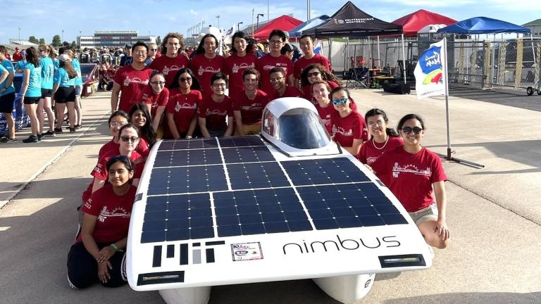 The MIT Solar Electric Vehicle Team poses with Nimbus, their solar car.