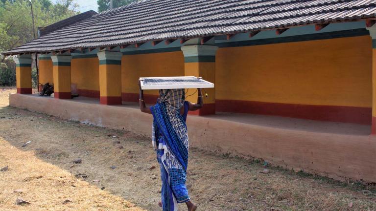 An Indian woman carries a solar panel developed by Khethworks, the first startup to emerge from the Tata Center. 