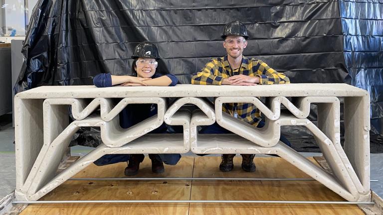 MIT Department of Civil and Environmental Engineering postdoc Hajin Kim-Tackowiak (left) and graduate student Zane Schemmer pose with the 3D-printed concrete bridge they designed and load-tested.