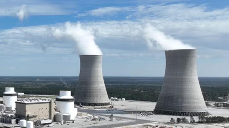 Photo of two large cooling towers emitting some steam.
