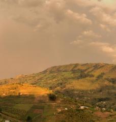 Hill in Uganda with rainbow across sky