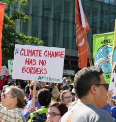 Photo of protesters with signs at a climate change rally.