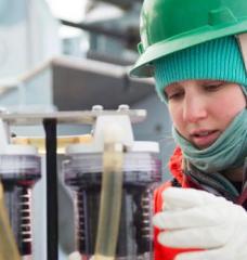 Lauren Kipp inspecting laboratory equipment