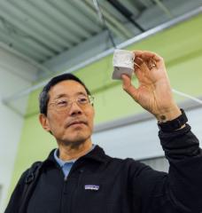 Professor Yet-Ming Chiang holds a mechanical test specimen of decarbonized cement.