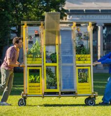 Zachary Rapaport (left) and Aleks Banaś move their farm cart across the MIT campus. The two graduate architecture students co-designed and built the cart.