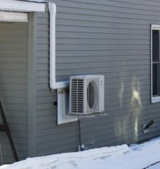 A heat pump is seen on the side of a home in Aroostook County, near Mars Hill.
