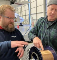 Lincoln Laboratory’s Ben Evans (left) and Dave Whelihan deployed this spool — featuring 230 feet of polymer fiber with embedded temperature and depth sensors — in the Arctic. 