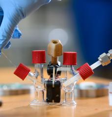 An H-cell modified with electrodes and an ion-conducting ceramic membrane to conduct sodium-air fuel cell experiments.
