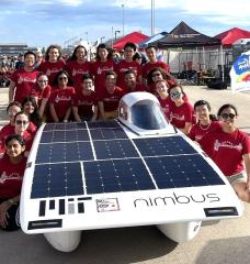 The MIT Solar Electric Vehicle Team poses with Nimbus, their solar car.