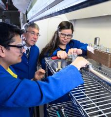 Based on a series of analytical studies, MIT chemical engineers have come up with an idea that would enable long-haul trucks to use clean-burning hydrogen in place of diesel fuel, thereby reducing their carbon emissions. Left to right: Sayandeep Biswas, William Green, and Kariana Moreno Sader are now building an experiment to test and fine-tune equipment key to their promising approach. 