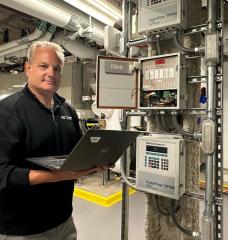 Fran Selvaggio, senior building management systems engineer in the MIT Department of Facilities, stands in the newly renovated Met Warehouse, where an innovative heat-recovery system captures heat rejected from the campus cooling system and uses electric heat pumps to generate heat for the building. 